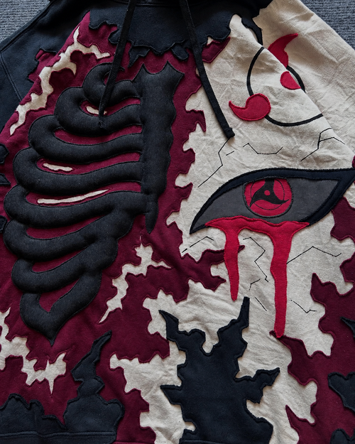 Close-up of Noctra Crimson Eclipse Hoodie featuring layered appliqué, embroidery and 3D skeletal detailing